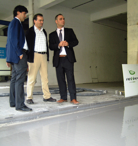 El director de INGURUBIDE, Javier Sánchez (en el centro) observa junto a Carlos Bermejo e Iñigo Barrenetxea, de Anhivel, la aplicación del comortero en el suelo.