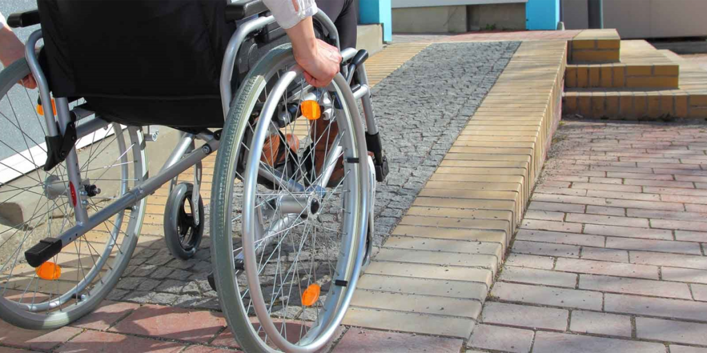 Un hombre en silla de ruedas delante de una rampa.