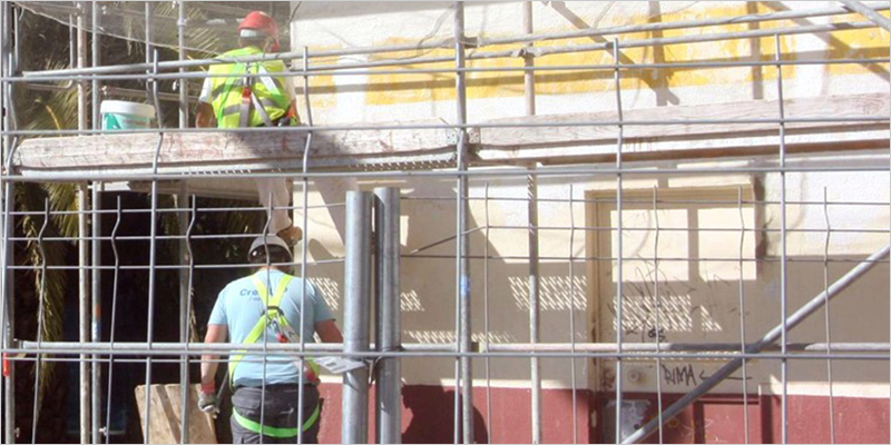 obreros rehabilitando fachada de edificio